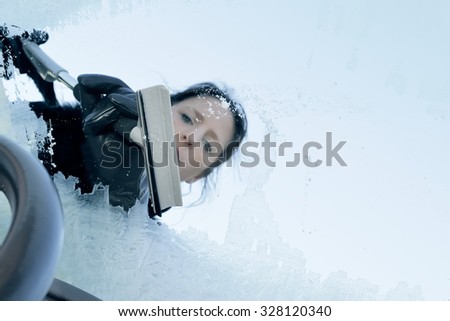 Winter Driving - Woman Scraping Ice from a Windshield
