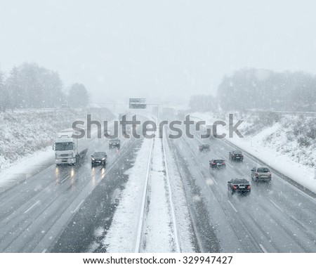 Winter Driving - commuter traffic on a highway - expressway - snowfall