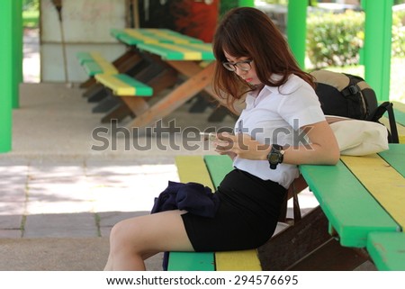 Portrait of thai woman student university beautiful girl using her smart phone.