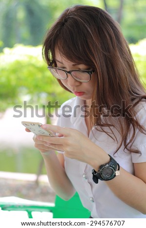 Portrait of thai woman student university beautiful girl using her smart phone.