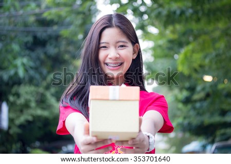 Portrait of thai teen beautiful girl in Chinese dress, happy new year and give gift, relax and smile.