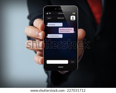 wireless, mobility and communications concept: businessman hand holding a phone with chat app on the screen