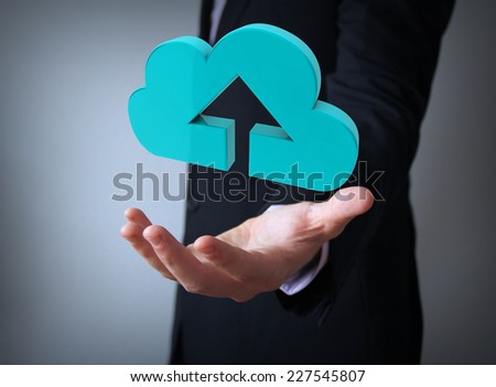 upload to the cloud concept: upload icon over businessman hand