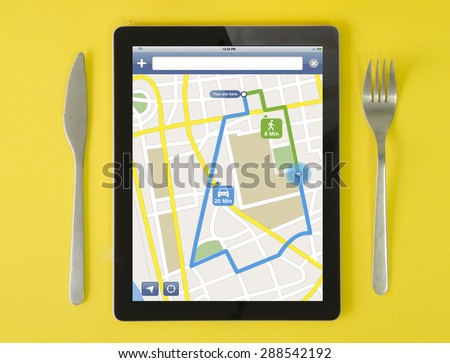 tablet gps concept: hipster breakfast with route planner app on a tablet screen. screen graphics are made up.