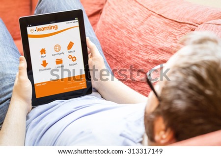 technology lifestyle learning concept: hipster man with online learning platform on a tablet at the sofa
