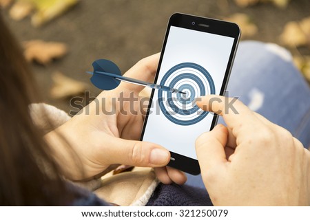Business excellence, corporate performance management, and achieving goals concept: woman holding a 3d generated smartphone with dartboard on the screen. Graphics on screen are made up.