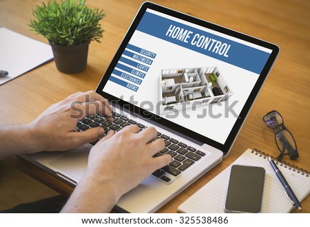 Businessman at work. Close-up top view of man working on laptop home automation. All screen graphics are made up.
