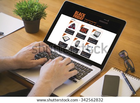 online shopping concept. Close-up top view of a man with black friday offers on laptop. all screen graphics are made up.