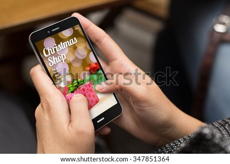 christmas season sales  concept: girl using a digital generated phone to shop online christmas gifts on the screen. All screen graphics are made up.