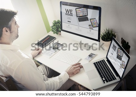 man working with devices with responsive website. All screen graphics are made up.