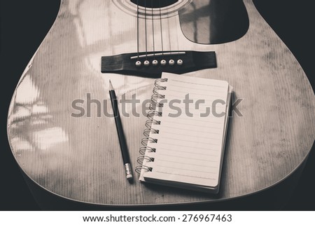 guitar,pencil and scrapbook ,Writing music in black and white