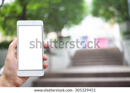 Business conceptual- Focused on left hand holding mobile The park blurred background
