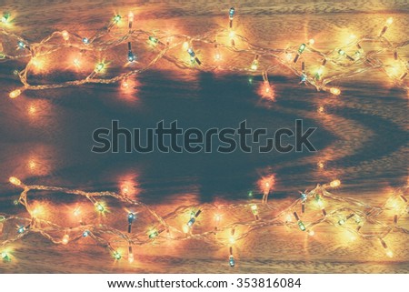 Light christmas top view with wooden background.In film tone
