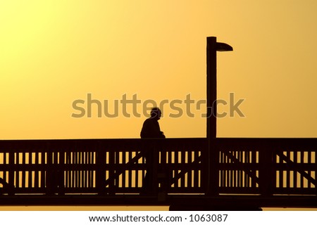 Elderly man walks boardwalk alone at days end