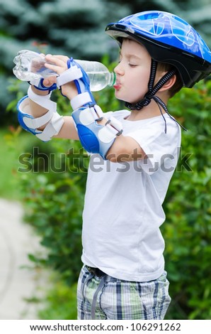 the lovely boy skater drinking water from a bottle