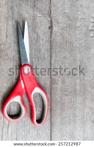 Red scissors. Object is isolated on wood background