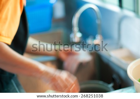 motion blur.woman doing the washing up in kitchen