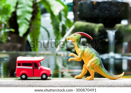 plastic dinasaur and red bus toy model