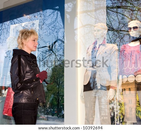 The young woman examining a show-window of shop