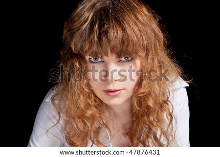 Young angry girl on black background portrait