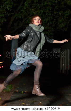 young woman jumping over a puddle