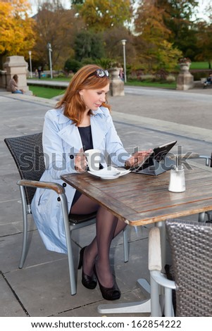 Business woman using tablet on lunch break.