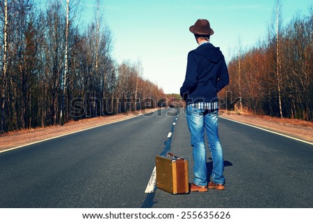Trip to holiday. Travel to a week-end.The man in jeans with a suitcase.