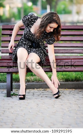 woman sat on a bench and leg massage because his legs hurt