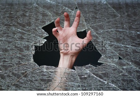 hand make their way through the broken glass