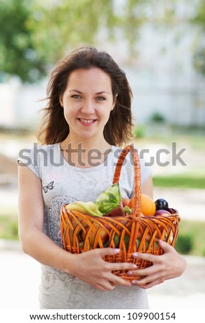 The caucasian girl with basket of food in the street