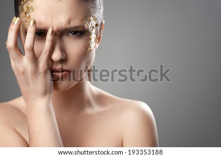 pretty girl with golden make-up art covers eyes