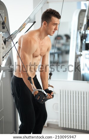 man exercising in trainer for triceps muscles in the gym