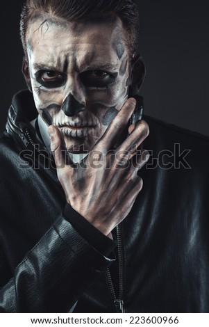 Portrait of pensive man with make-up of the skull