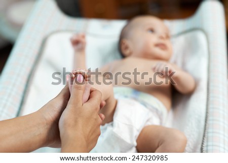 Mom checks reflex child moving her fingers on foot