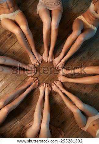 feet of dancers seated circle on the floor