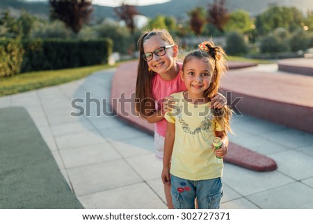 funny girls arestaying and  smilling  in the park