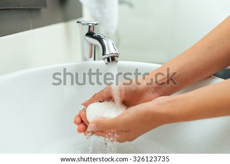 girl washes her hands with soup in the bathroom