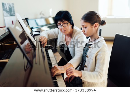 music teacher shows how to play the piano