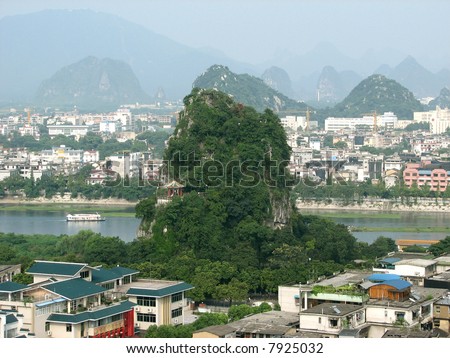 This is a jungle covered hilly peak that houses many caves and temples in the city of Guilin China.