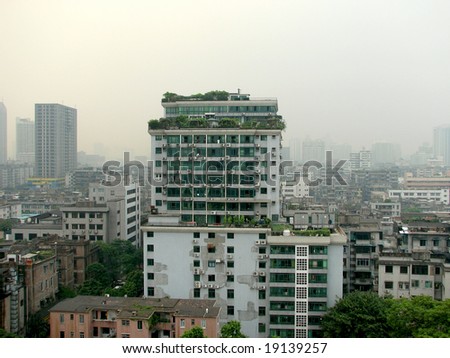A large high rise housing building covered with plants in downtown Guangzhou, China.