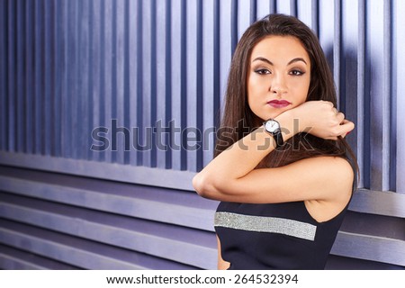 Beautiful brunette girl showing wrist watch. Demonstration of mechanical watches with leather strap. Automatic Watch. Time is money.