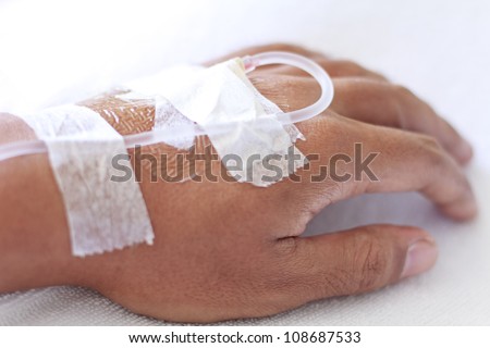 closeup shot of a patient\'s hand with saline intravenous (iv)
