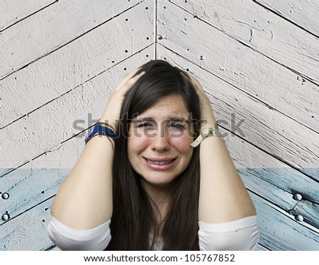 pretty girl crying over wooden background