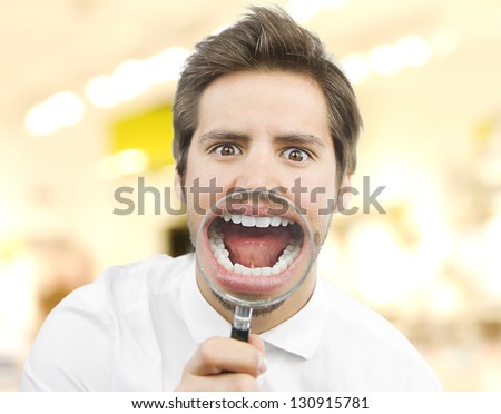handsome man with a magnifying glass in his mouth