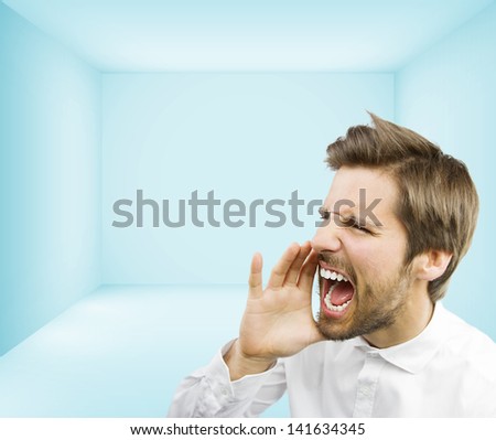 young handsome man shouting in an empty room