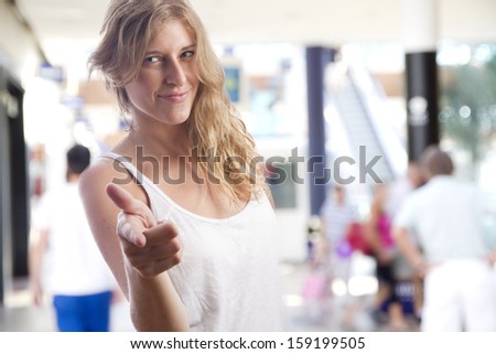 young woman pointing you in a shopping center