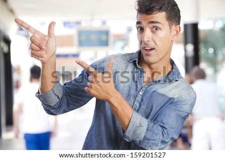 young man pointing up in a shopping center