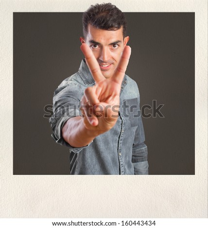 young man victory gesture on photo frame