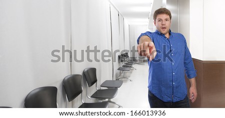 young man pointing you on waiting room background