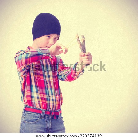 Boy pointing with a slingshot